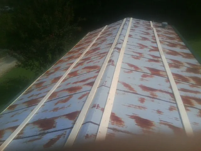 Rusted metal roof panels with new wood purlins before replacement — Storm Damage Roof Repair in Ladoga by Roofing Brothers