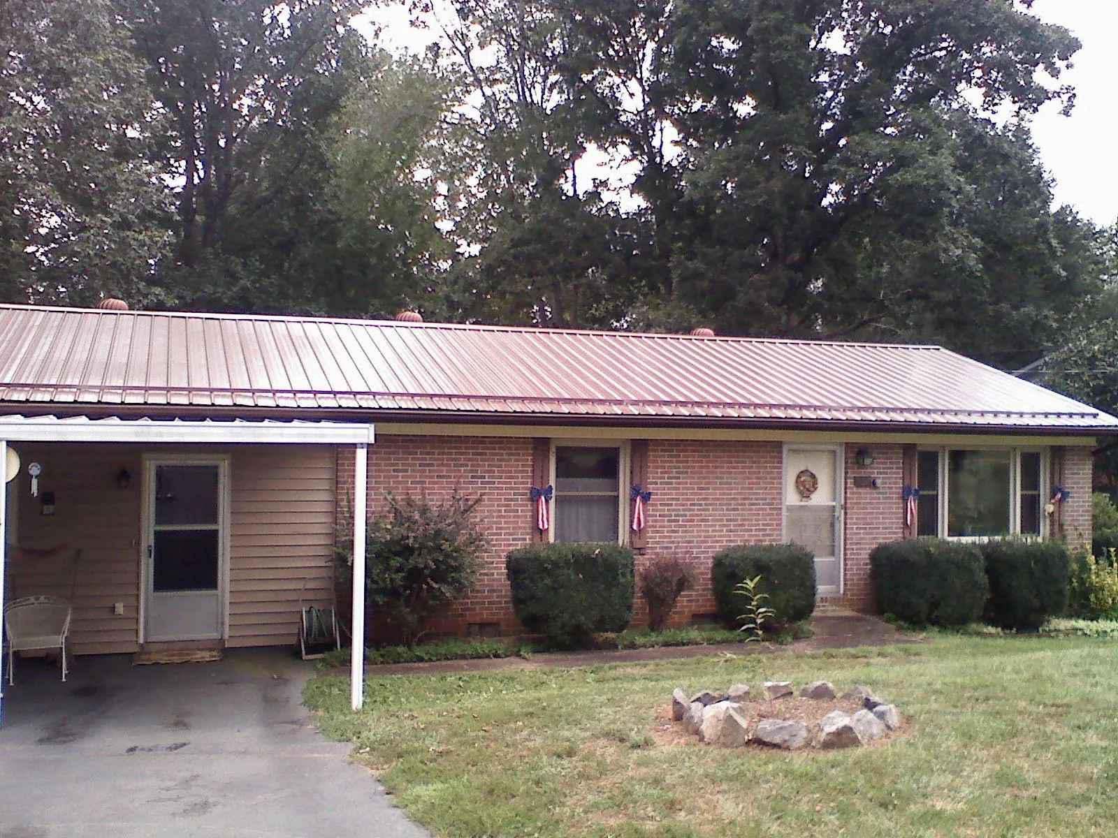 Bronze metal roof and carport on a brick ranch home — Roof Repair work by our crew in Ladoga